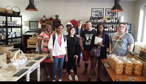 a group of college age students are standing in the store of a local brewery