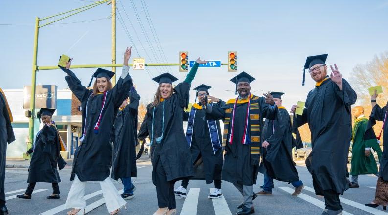 A group of students cross the street.