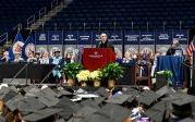 Photo of a man speaking at a podium to a crowd of people.