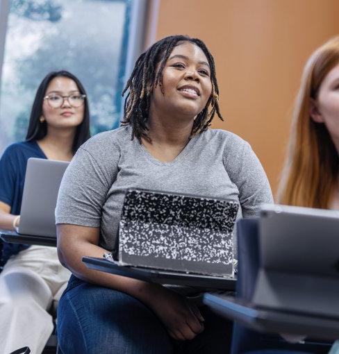 Students in a classroom, watching a lecture