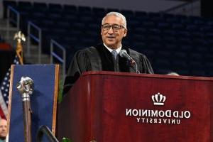 Photo of a man speaking at a podium.